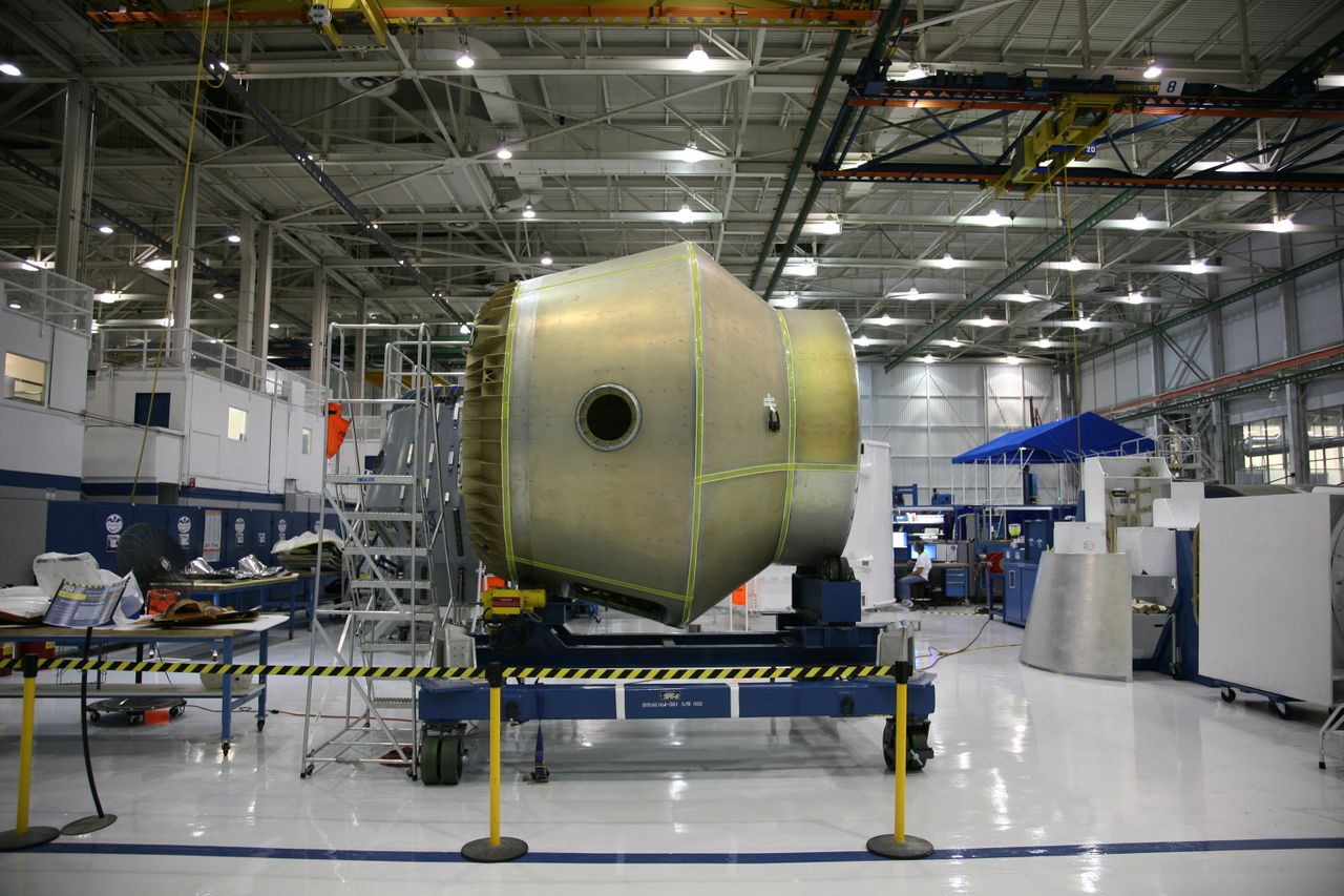 Manufacturing engineer reviewing technical drawings beside CNC equipment in a U.S. defense manufacturing facility.